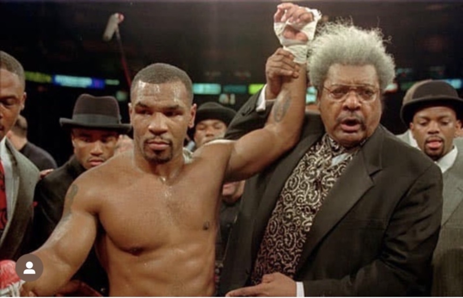Don King raising a boxer's hand in victory